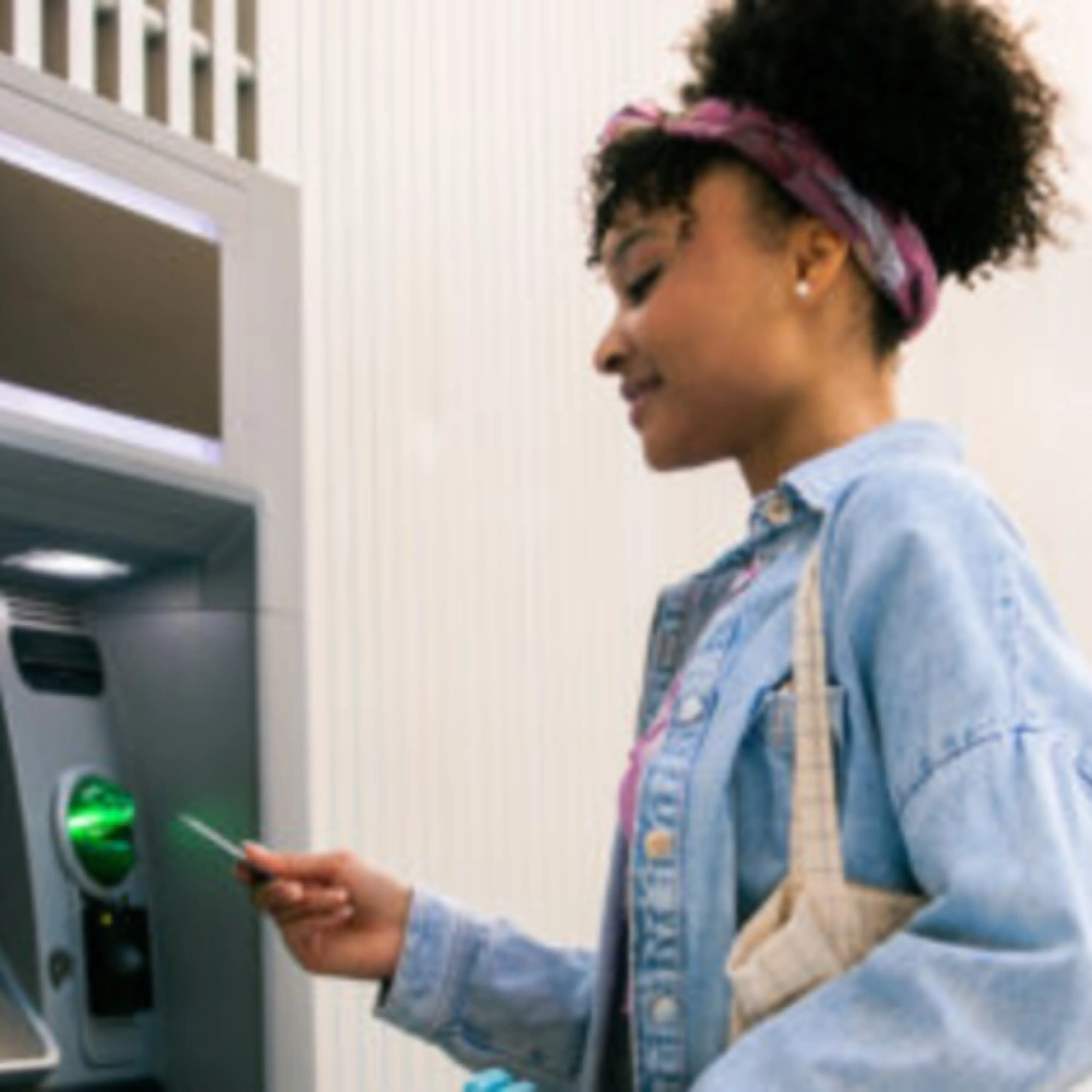 A person taking money out of an ATM.