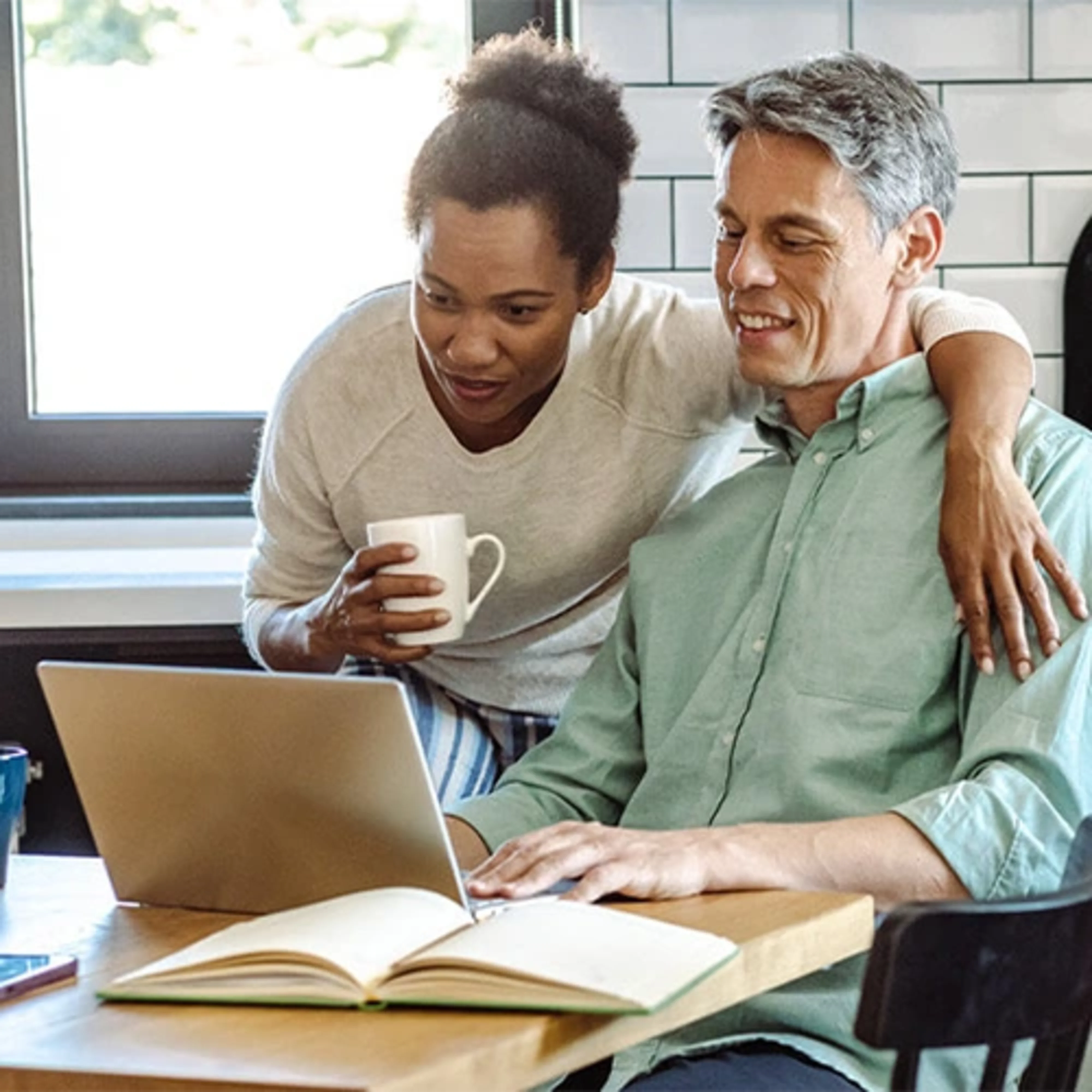 A couple with their laptop find out how much they should save with the Emergency Fund Calculator.