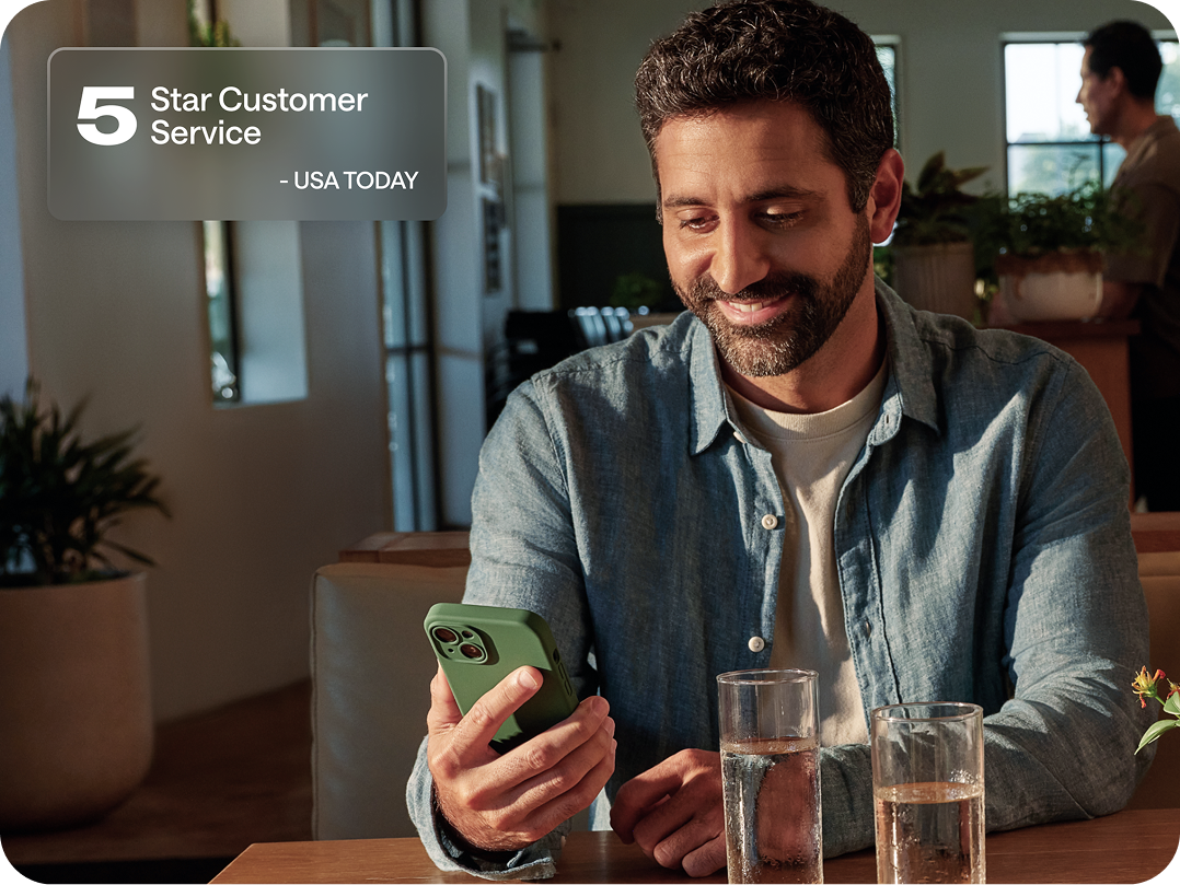 A smiling man in a blue shirt uses a green-cased phone at a table. Text reads "5 Star Customer Service - USA TODAY."