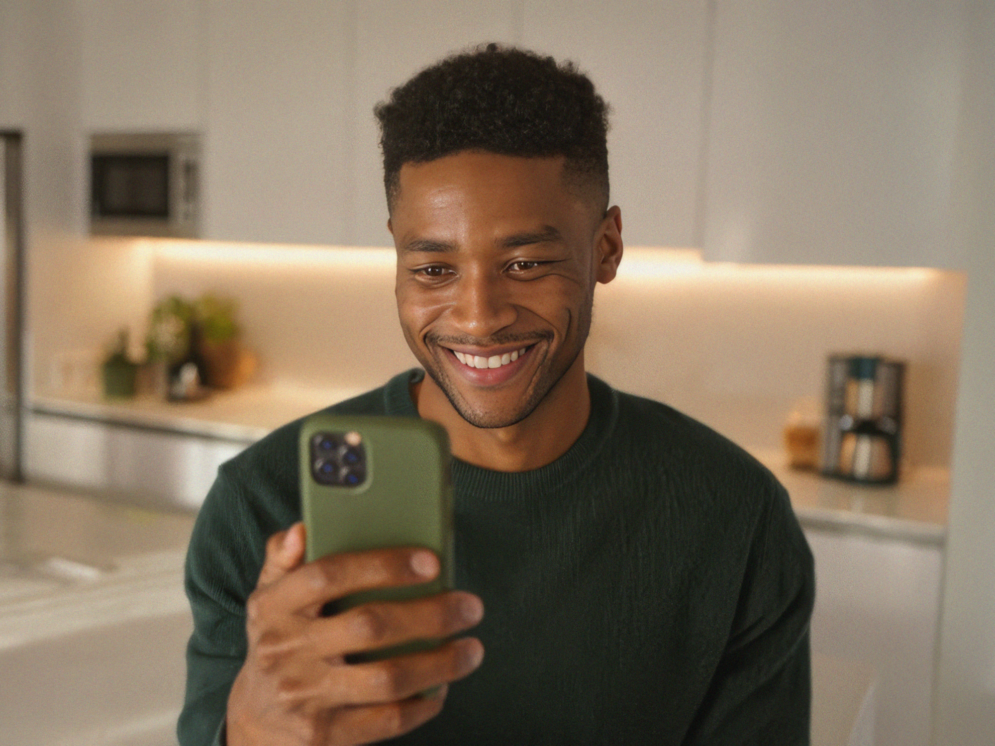 A person smiling while looking at their phone.