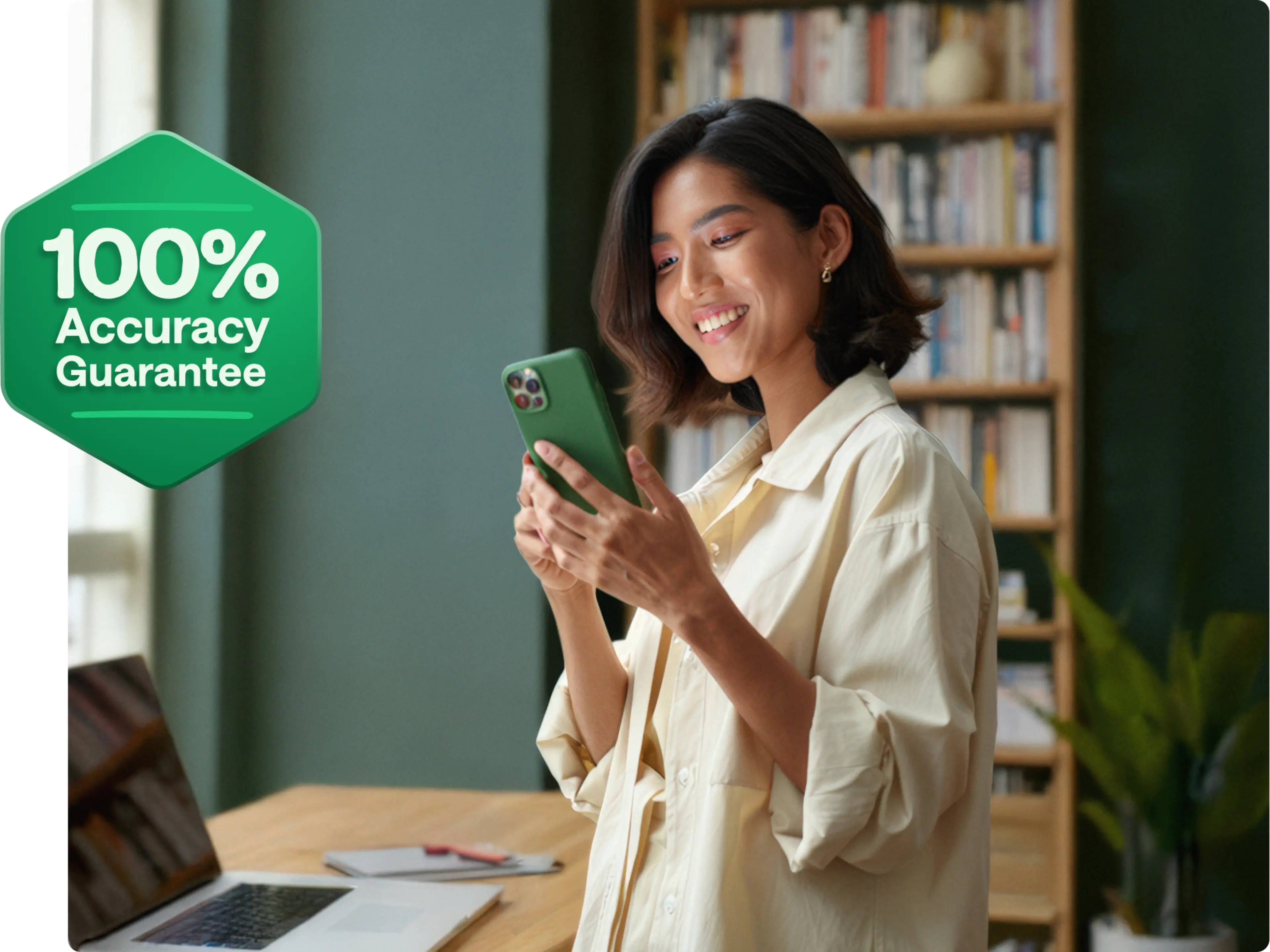 A person looking at their phone. There is a sign that says "100% Accuracy Guarantee."