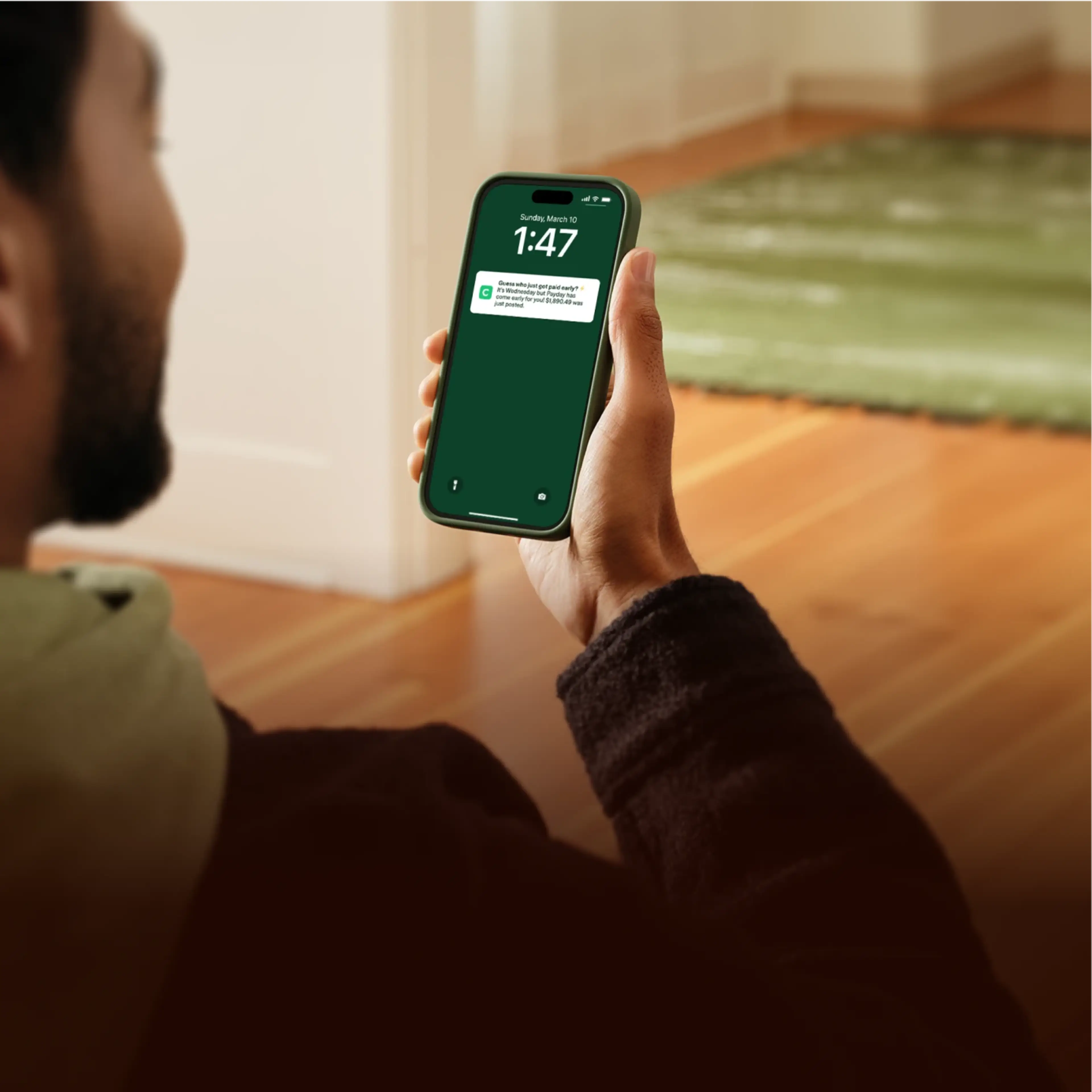 Person holding a smartphone displaying a Chime notification about early payday.