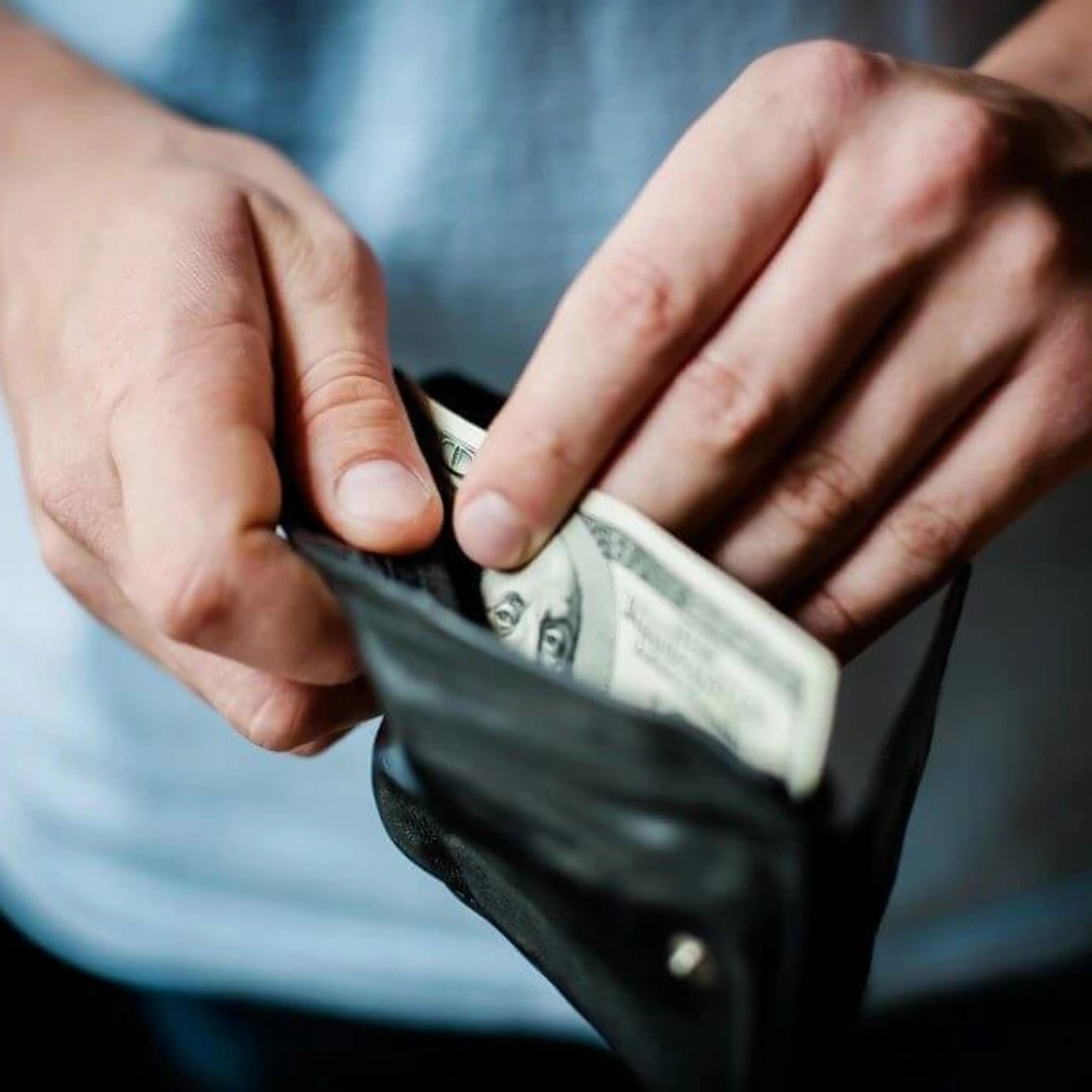 Closeup of someone opening wallet.