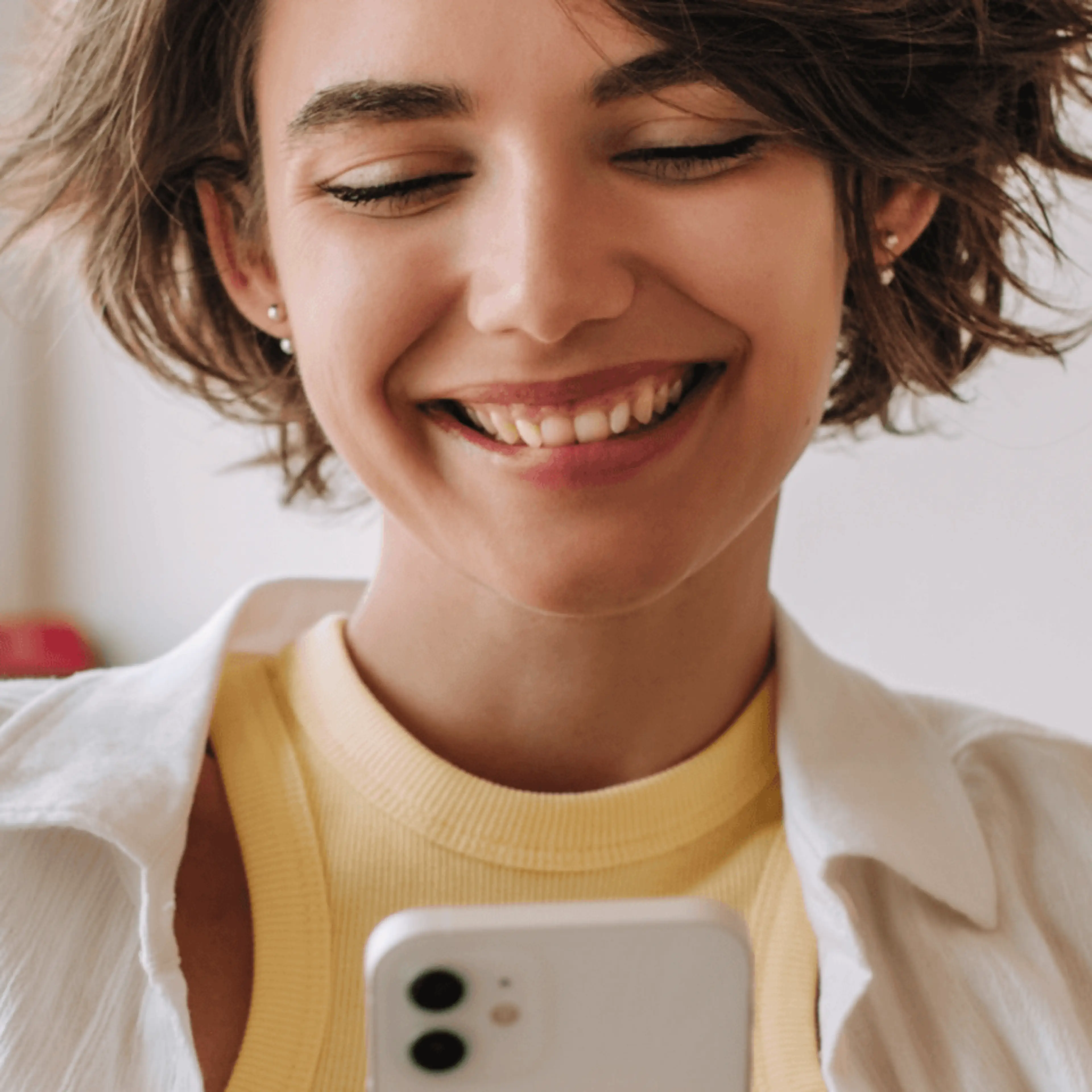 Girl smiling at phone yellow shirt resources what is second chance banking?
