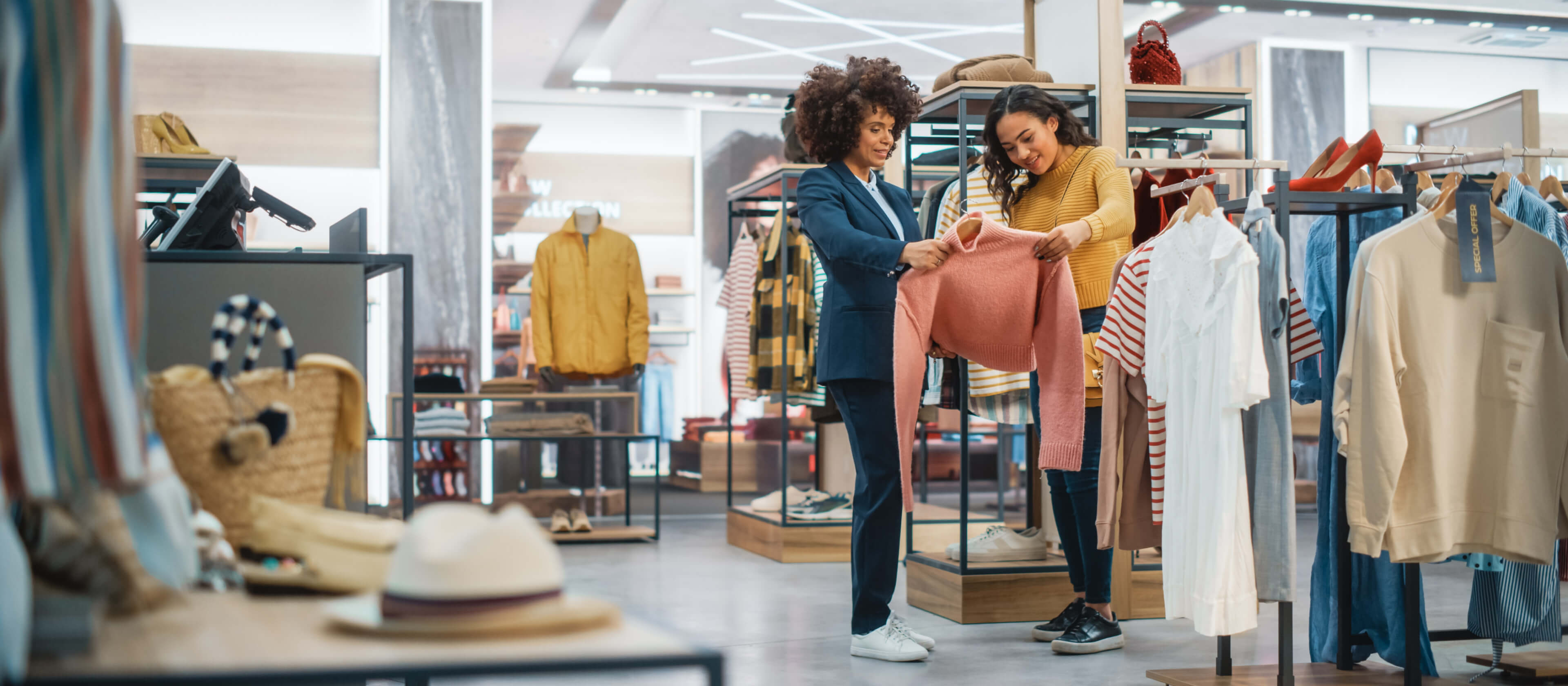 Two women shop in a retail clothing store.