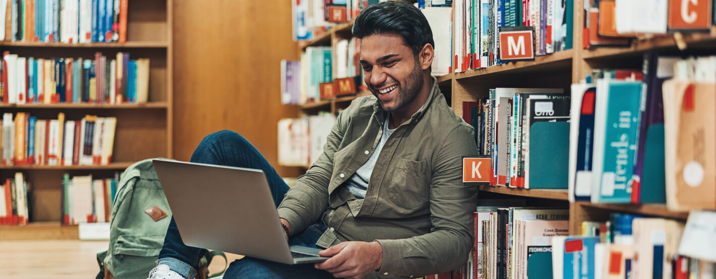 Student at library using laptop to review loan options